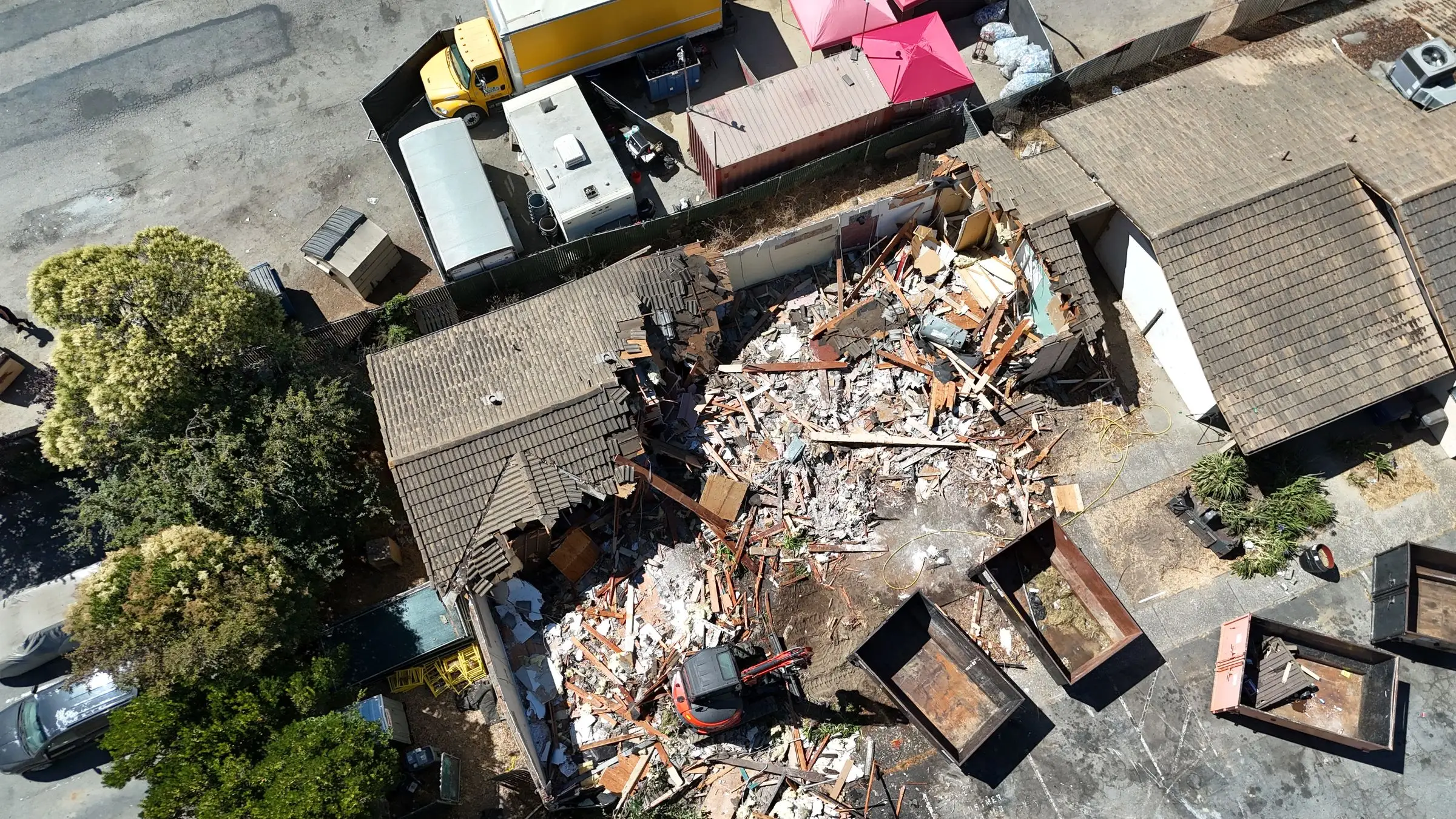 Aerial view of a building demolition site between commercial buildings
