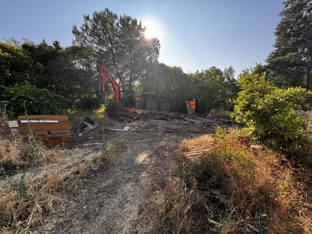 Dual double-wide demolition in progress with excavator