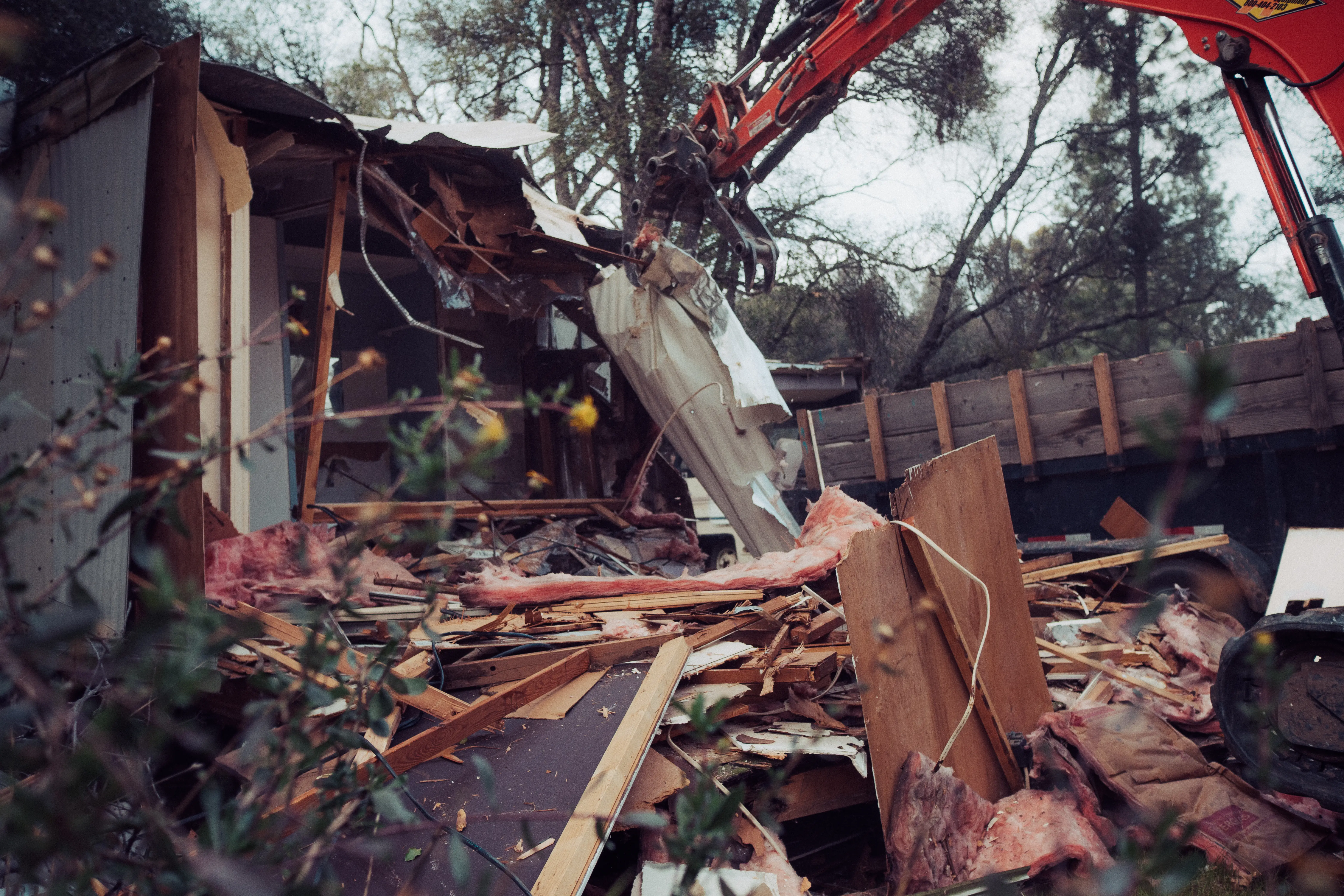 Mobile home demolition — excavator tearing down structure